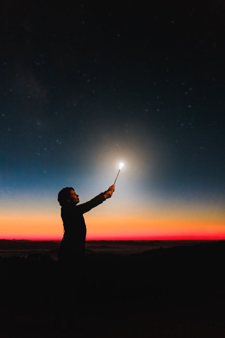 person holding roman candle at night