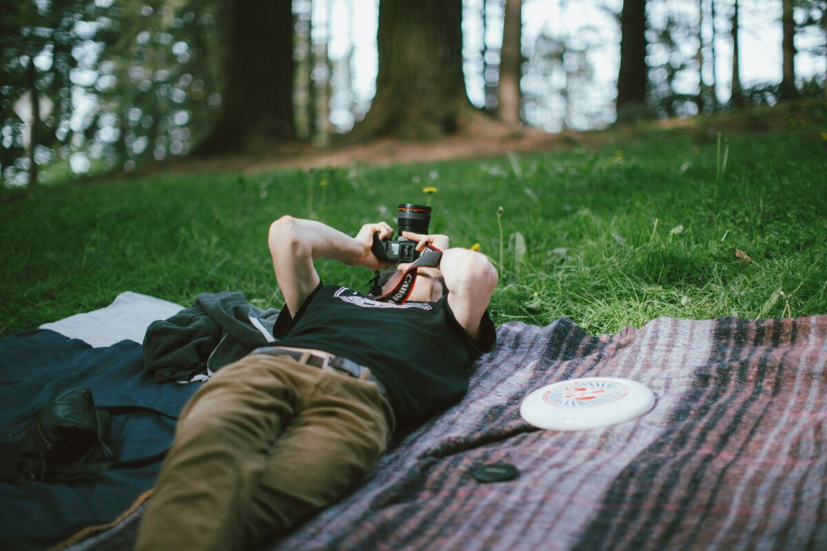Man lying on blanket taking a picture