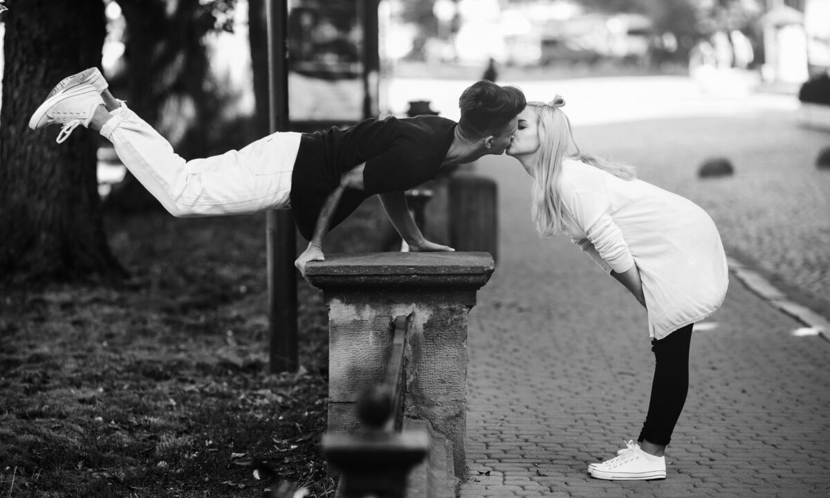 Man performs an acrobatic trick near a girl
